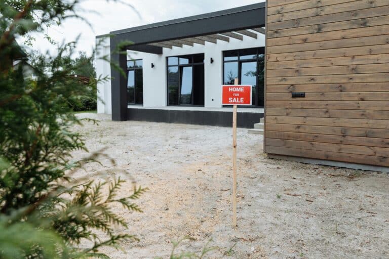 Modern house with a for sale sign in the front yard