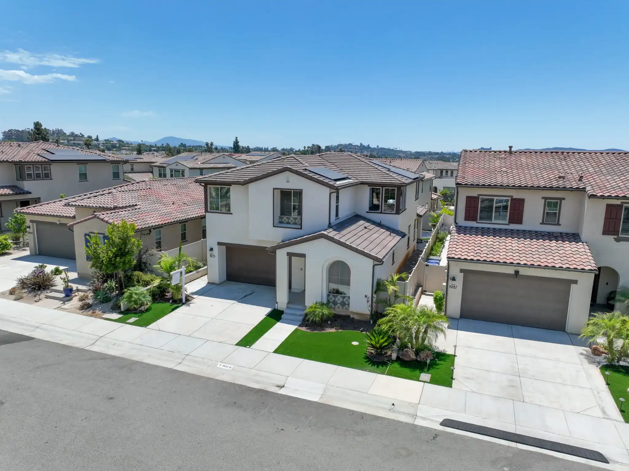 Two-story homes with tile roofs on a quiet street