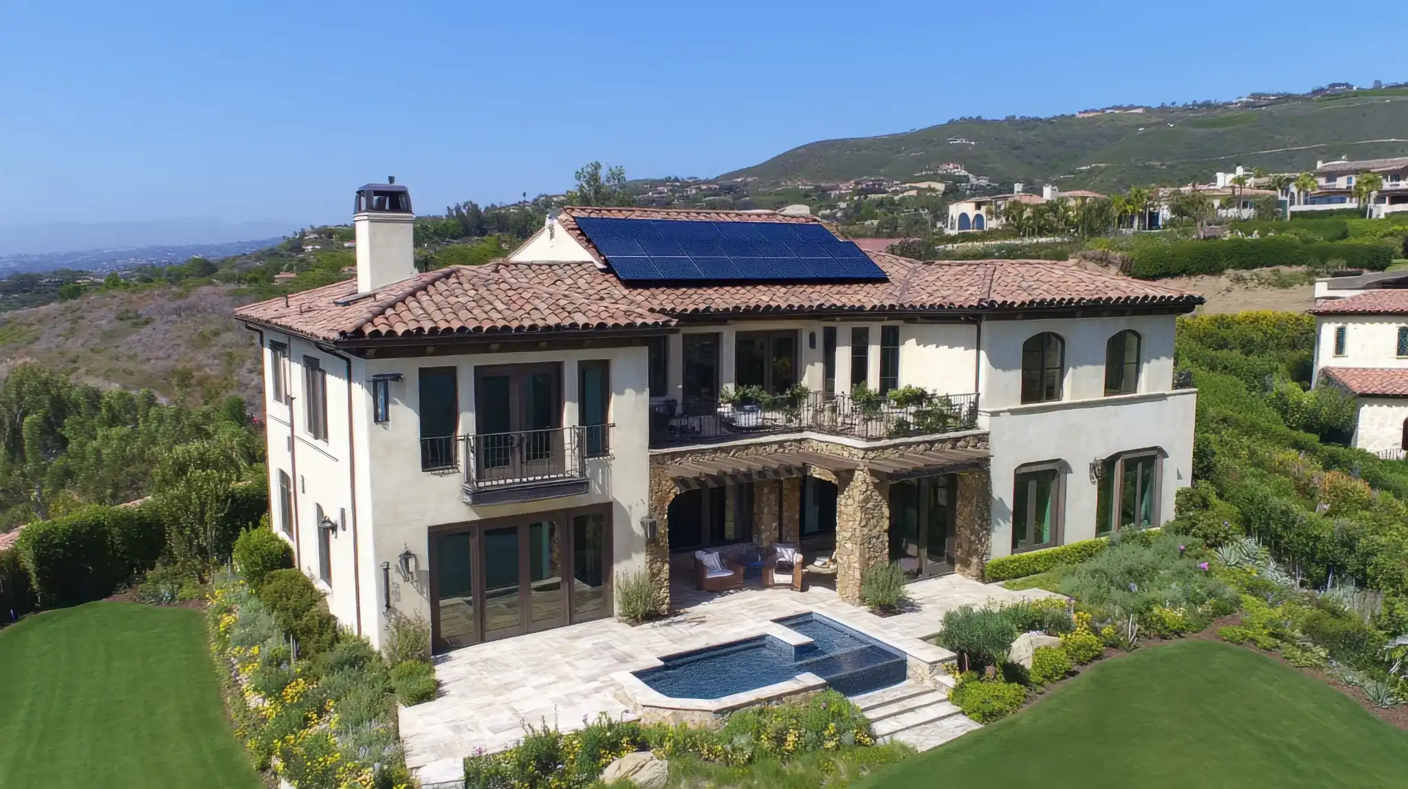 Mediterranean-style hillside home with a landscaped yard